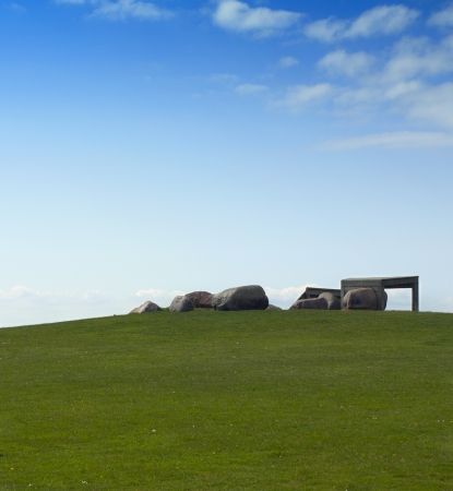 green lawn with large rocks and blue skyの写真素材