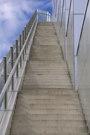 a new set of concrete steps with thick safety glass and stainless steel handrailの写真素材