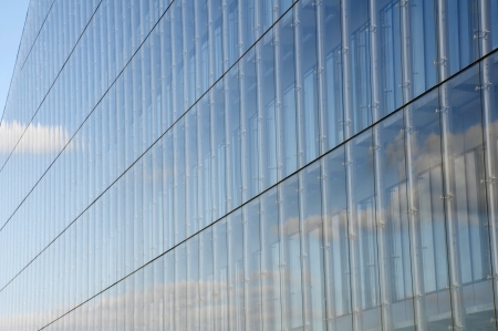 the clouds reflect from the  glass of this modern glass office buildingの写真素材