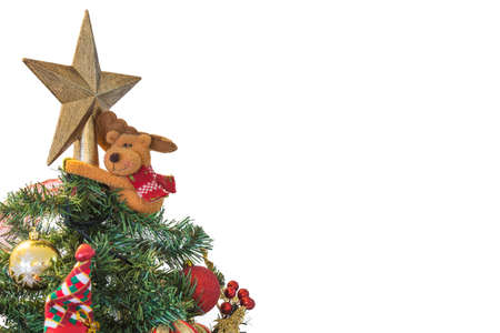 Green Christmas tree decorated with a star on top hugged by a reindeer with red and gold Christmas balls; Santa Claus doll; ribbons; red cherries with golden leavesの写真素材