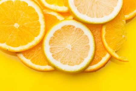 Slices of oranges and lemons, fruits full of juice with which juices are made, the sweetest orange than the lemon that is much more acidic, both full of vitamins C and very healthyの写真素材