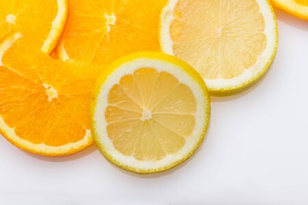 Slices of oranges and lemons, fruits full of juice with which juices are made, the sweetest orange than the lemon that is much more acidic, both full of vitamins C and very healthyの写真素材