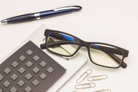 Calculate the money and interest helped by a calculator and a good prescription glasses; Money and papers and clips on the table. Bank interest, finance, calculationsの写真素材
