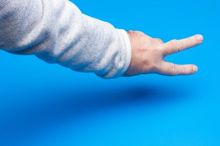 Adult hand with fist and fingers making signs and symbols and communicating emotions and moods without saying words.の写真素材
