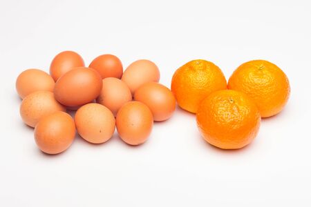 Still life of eggs and tangerines, eggs have cholesterol but have hundreds of positive properties, tangerine is a fruit with many vitamins.の写真素材