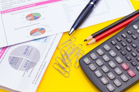 Papers, glasses and calculator to make calculations of the invoices we receive, to make graphs and statistics of our expenses or benefits. scientific calculator used by science studentsの写真素材