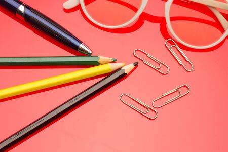 Diverse office supplies, clips, pencils, pen, staples, stapler, money, coins, compass; professional office or high school or university student office.の写真素材