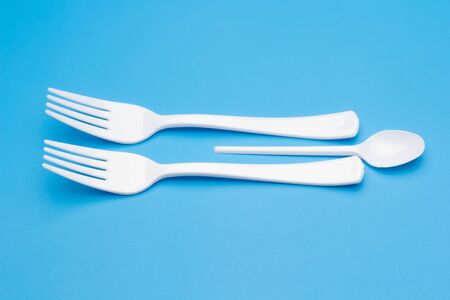 Cutlery for eating white and made of plastic and transparent glass cups; Cutlery and glasses...