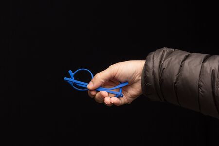 Visual health in the glasses, give away glasses for vision correction, colored designer glasses on a black background. Colored lenses in the hand of an adult person. Correction in the lenses of the glasses.の写真素材