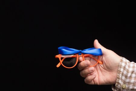 Visual health in the glasses, give away glasses for vision correction, colored designer glasses on a black background. Colored lenses in the hand of an adult person. Correction in the lenses of the glasses.の写真素材