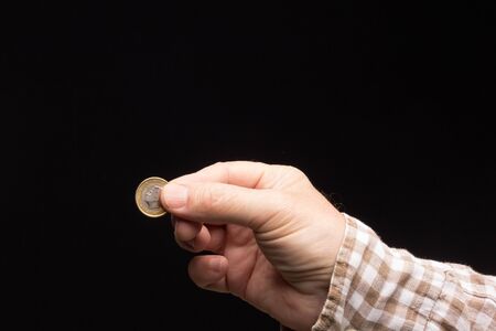 Alms in the hand of a white adult, beggar asking for money. Coins in the hand of an adult to make...