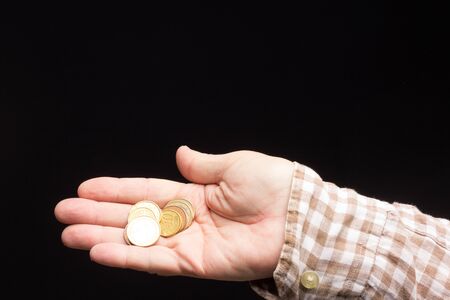 Alms in the hand of a white adult, beggar asking for money. Coins in the hand of an adult to make small purchases in neighborhood stores. Pennies in handの写真素材