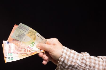 Wad of euro banknotes in the hand of a person, prepared to buy or to save and enter the bank....