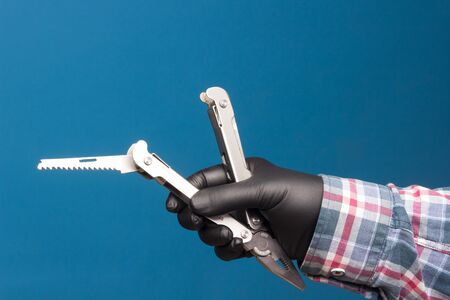 Multipurpose tool, knife, screwdriver, saw, in the hand of an expert and adult person, to get out of...