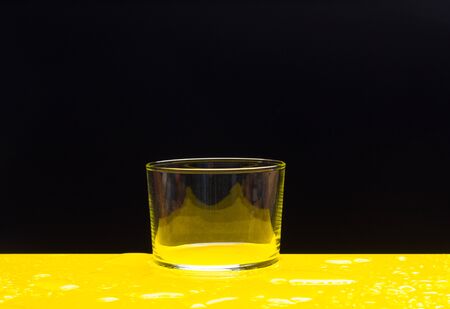 Splash and splash of water in a glass that is filling with fresh, clear water. Drinking water ready to be drunk. Mineral water.の写真素材