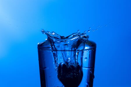 Clear, drinking water falls into a clear glass, healthy, wholesome, fresh water with no odor or taste. Splash of water drops splashing onto the surface. Jet of water entering the glassの写真素材