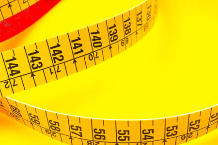 Yellow tape measure for measuring perimeters of objects; tailor's and dressmaker's tape for taking...