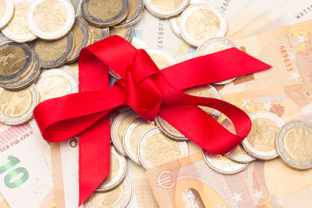 Money as a gift; giving money as a gift at anniversary or Christmas parties; money with a red ribbon; when we lack ideas, money is given as a gift.の写真素材
