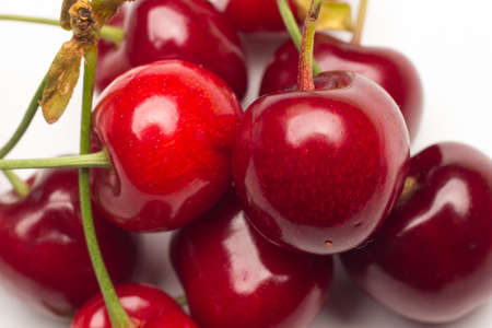 set of small red cherries on a white background full of vitamins and tasty flavor, sweet and ideal for eating raw or in desserts.の写真素材