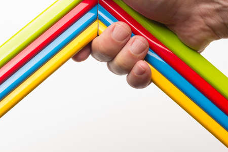Hand, fingers and range of colors; colored pencils, full range; colored angles held by adult handの写真素材