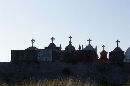 Silhouettes at sunset of crosses in a cemetery in Galicia, Spain. Crosses and symbology in a...