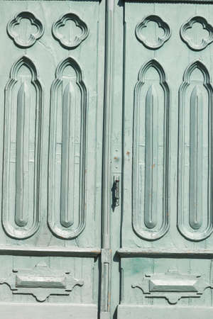 Old church door worked with green geometrical drawings in Galicia, Spain.