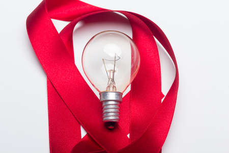 incandescent bulbs and red ribbon on a white backgroundの写真素材