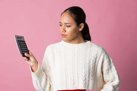 Young latina girl with calculator in handの写真素材