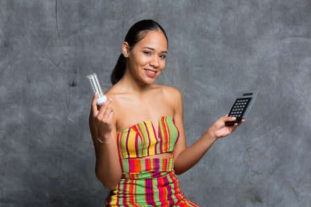 Young latina girl with calculator in handの写真素材