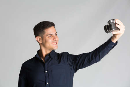 Selfie with old analog camera on studio backgroundの写真素材