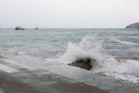 Waves, bad sea, waves crashing against the harbor and against the rock.