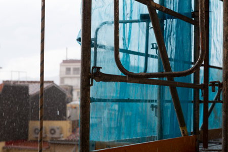 Laundry drying on a clothesline on a balcony is getting wet during a sudden rain showerの写真素材