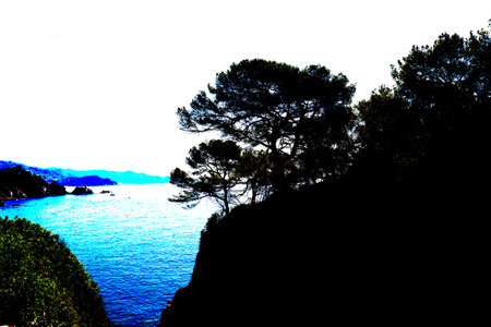Boats sailing in the distance on beautiful turquoise water with rocky cliffs in the foreground