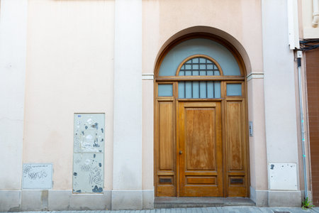 Weathered red wooden double door with graffiti tags, showing signs of age and decay