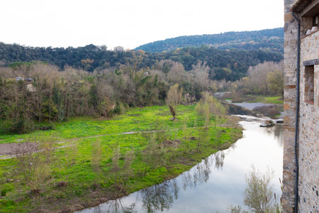 Scenic view of the medieval bridge and historic village of Besalu, Catalonia, Spain, reflecting in...