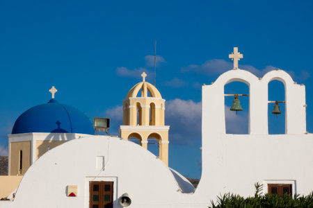 Picturesque white church with blue dome overlooking the Aegean sea on a sunny day in Santorini, Greeceの写真素材