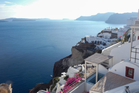 White painted houses and blue domed churches creating a picturesque cityscape in Oia, Santorini, Greeceの写真素材
