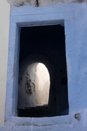 Picturesque alley with narrow tunnel with whitewashed walls, stone pavement, creating a charming Mediterranean atmosphere on the Greek islands, Greeceの写真素材