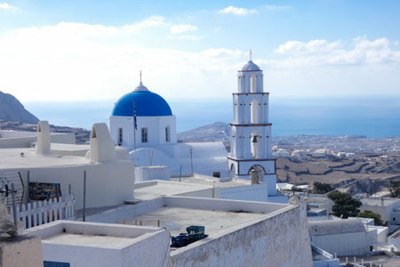 Traditional greek orthodox church with waving flag and blue dome in Santorini, Greece