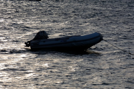 Small wooden boat floating on calm blue water near the coast.