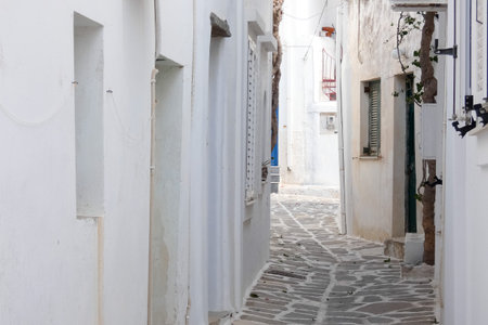 Local man walking away on a narrow cobblestone street in Paros town, Greeceの写真素材