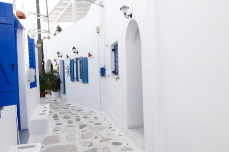Local man walking away on a narrow cobblestone street in Paros town, Greeceの写真素材