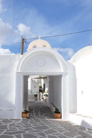 Picturesque alley with narrow tunnel with whitewashed walls, stone pavement, creating a charming Mediterranean atmosphere on the Greek islands, Greeceの写真素材
