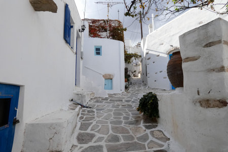 Local man walking away on a narrow cobblestone street in Paros town, Greeceの写真素材