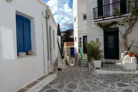 Local man walking away on a narrow cobblestone street in Paros town, Greeceの写真素材