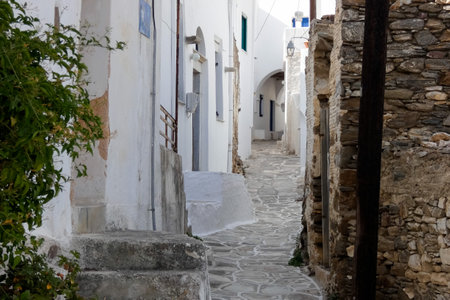 Local man walking away on a narrow cobblestone street in Paros town, Greeceの写真素材