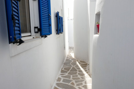 Local man walking away on a narrow cobblestone street in Paros town, Greeceの写真素材