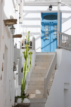 Local man walking away on a narrow cobblestone street in Paros town, Greeceの写真素材