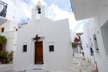 Traditional white bell tower with cross on top in a Greek island villageの写真素材