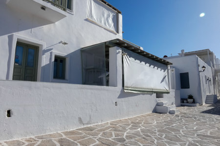 Local man walking away on a narrow cobblestone street in Paros town, Greeceの写真素材